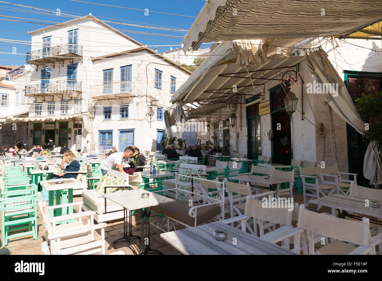 HYDRA, Grecia - 25 ottobre 2015: persone nei terrazzi di caffè sulla banchina del porto di Hydra Foto Stock