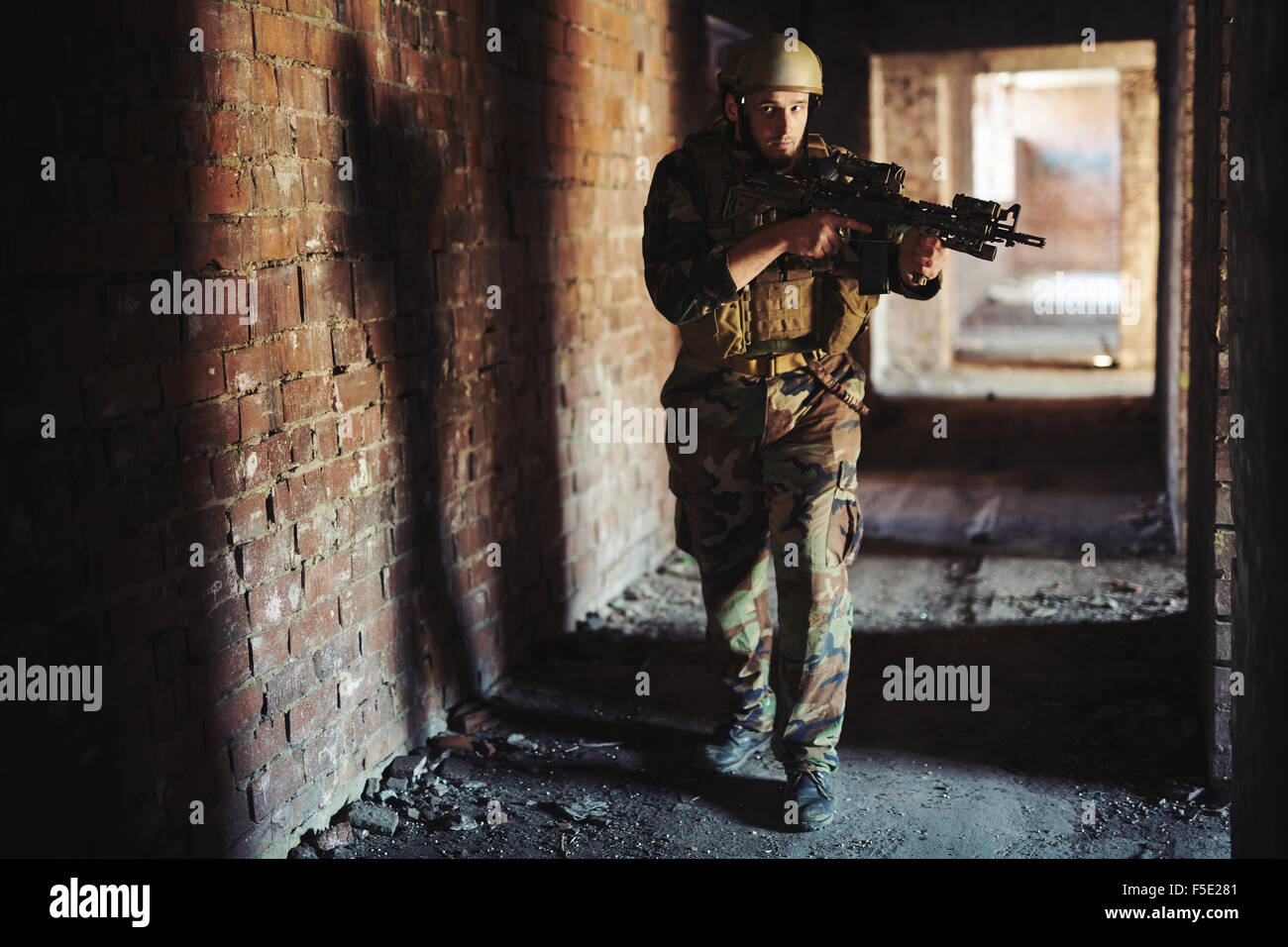 Giovane soldato in camuffamento portando la pistola Foto Stock