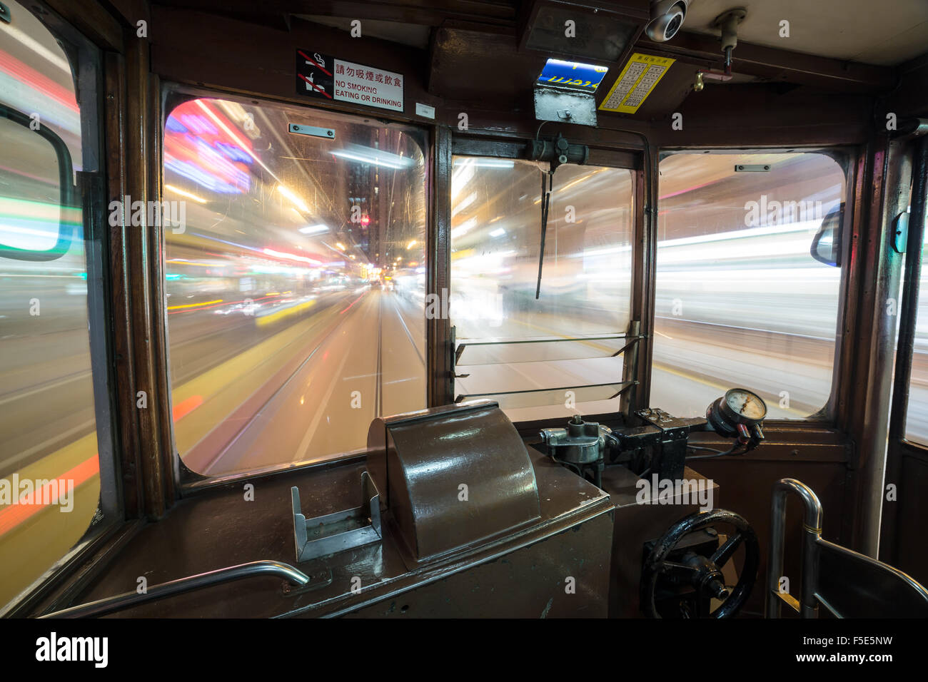 All'interno di un Tram auto correre attraverso Hong Kong Island strade di notte. Ampio angolo e una lunga esposizione sono utilizzati. Foto Stock