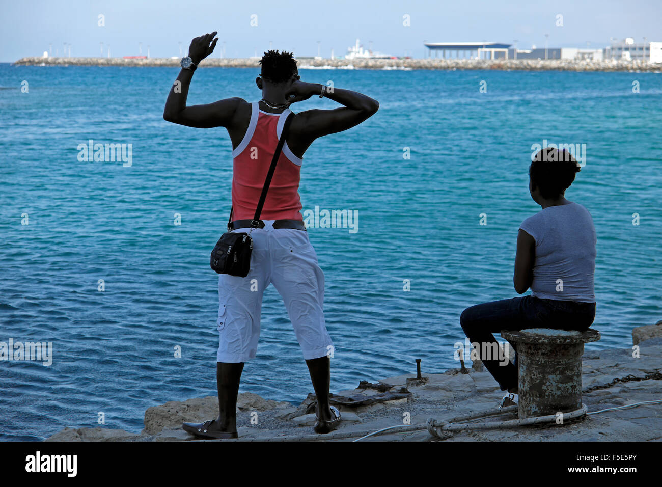 Persone sedute lungo la banchina all'entrata di Kyrenia porto di Cipro Nord KATHY DEWITT Foto Stock