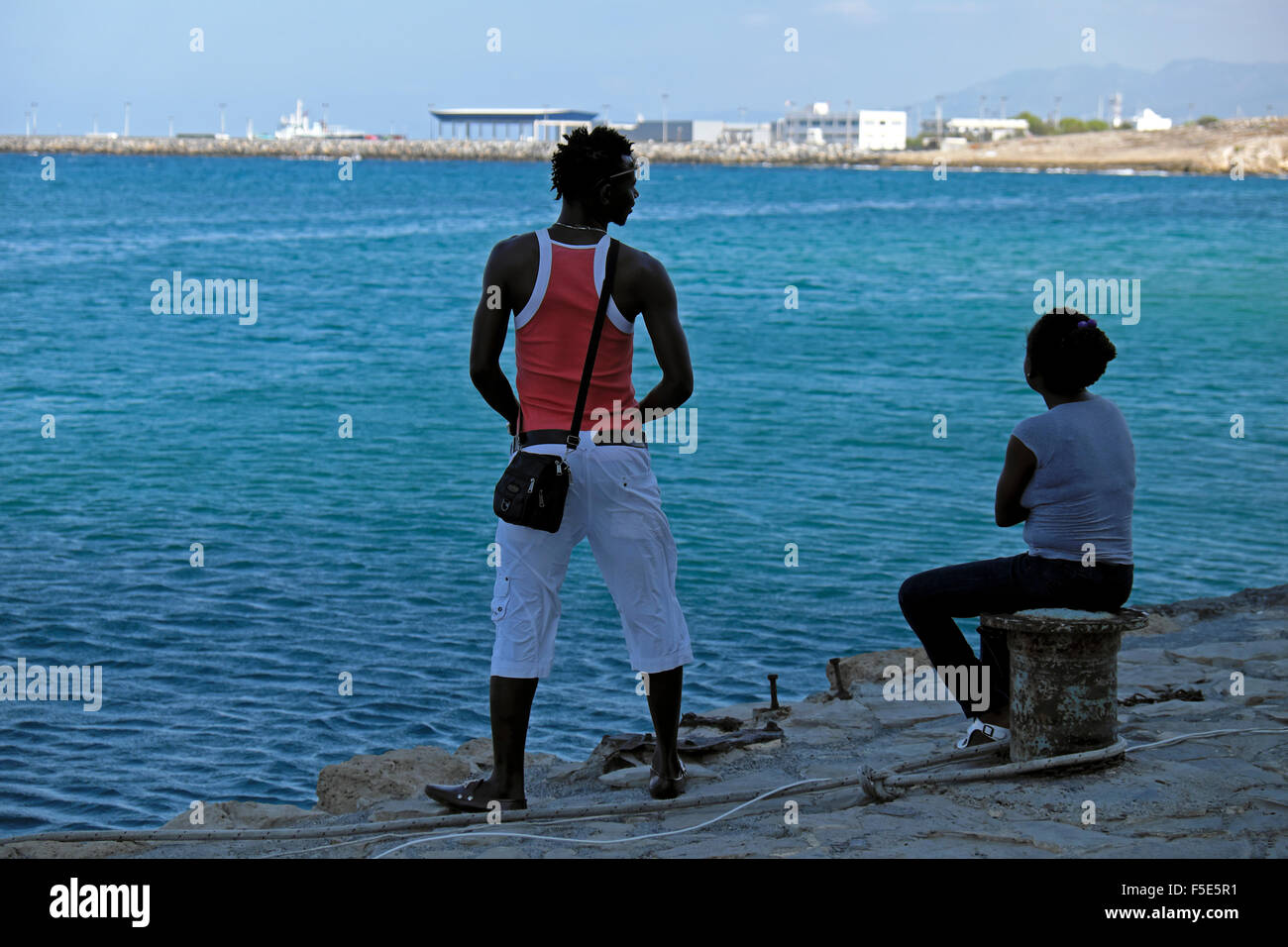 Turisti persone seduti lungo la banchina all'ingresso del porto di Kyrenia a Cipro Nord KATHY DEWITT Foto Stock