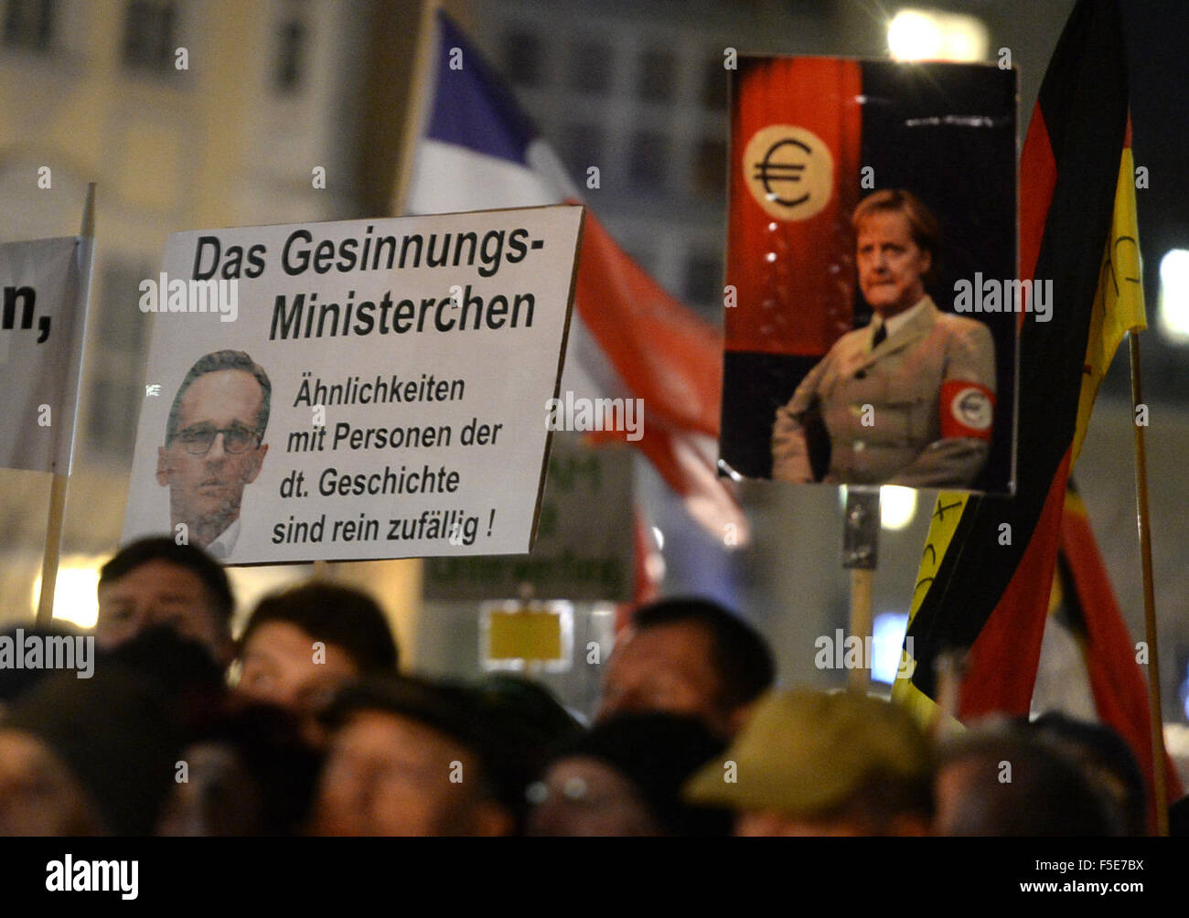 Dresden, Germania. 2° Nov, 2015. I sostenitori di Pegida, un anti-immigrati del gruppo il cui nome si traduce approssimativamente a patriottici europei contro l islamizzazione dell' Europa, portano un cartello che recita "ministro patriottica - smiliarities con persone di storia tedesca sono purly dalla possibilità' e mette in mostra una foto del ministro tedesco della giustizia Heiko Maas duringa Pegida rally a Dresda (Germania), 2 novembre 2015. Foto: Arno Burgi/dpa/Alamy Live News Foto Stock