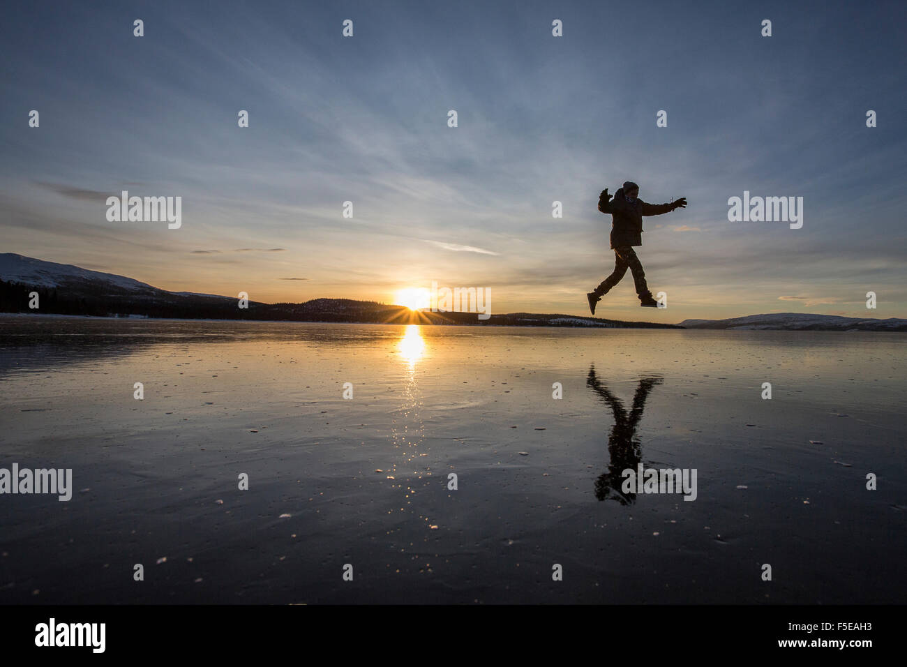 Escursionista salta sulla superficie ghiacciata del lago Limingen, Rorvik, Borgefjell National Park, il Trondelag, Norvegia, Scandinavia, Europa Foto Stock