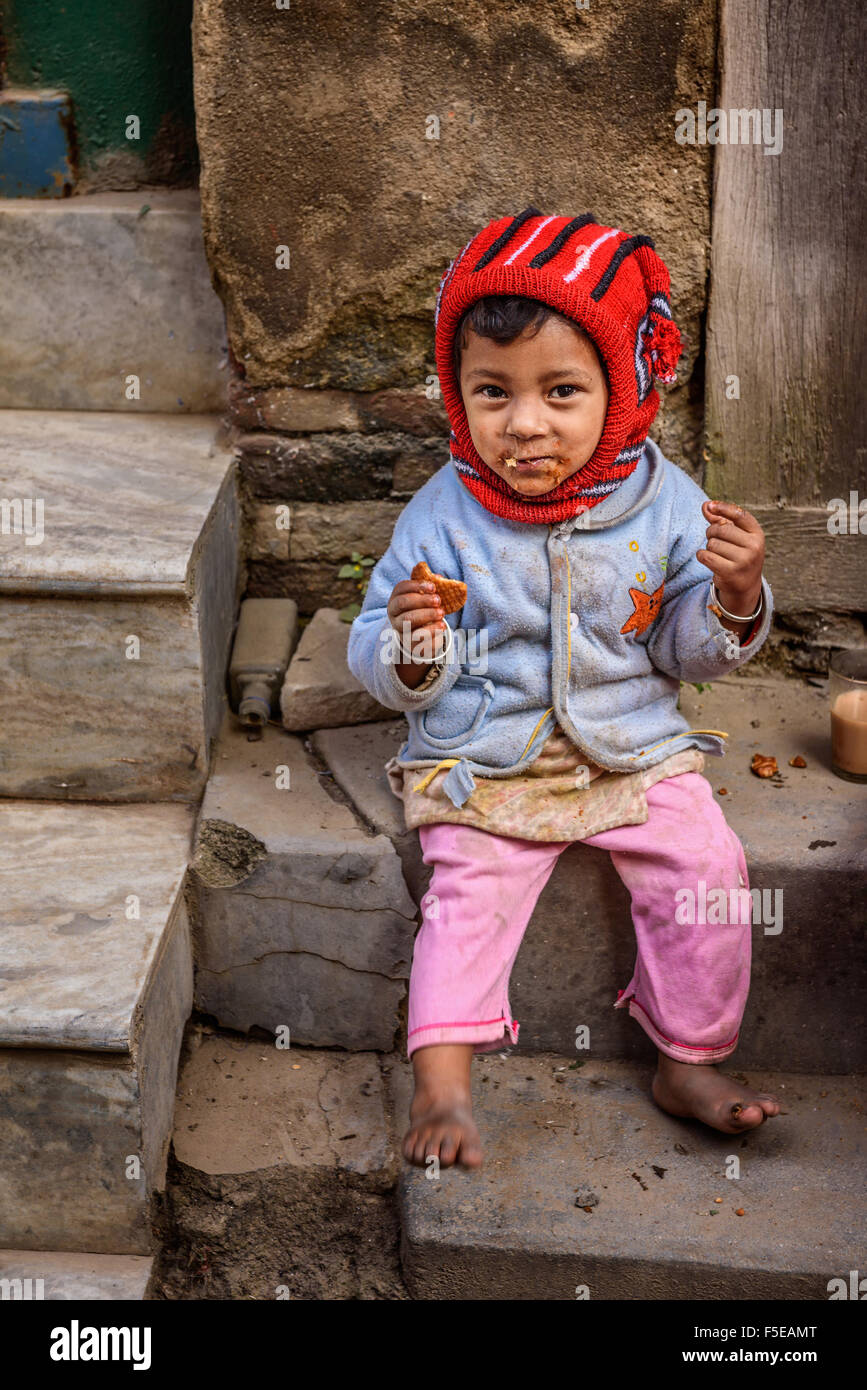 Una ragazza povera in Nepal mangiando un cracker in strada di Kathmandu Foto Stock