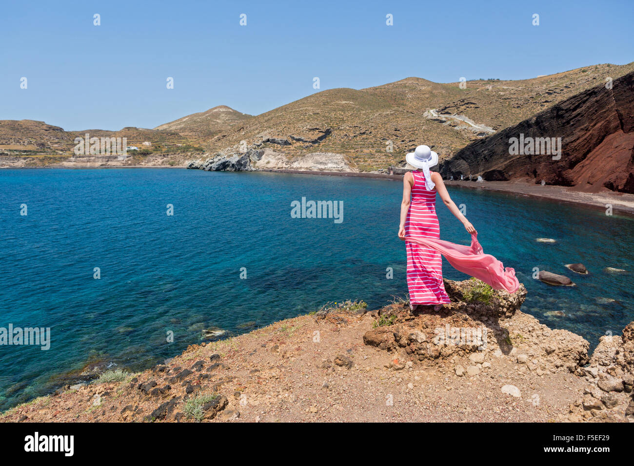 Donna Sorge Su Una Scogliera E Guarda Alla Spiaggia Rossa Di