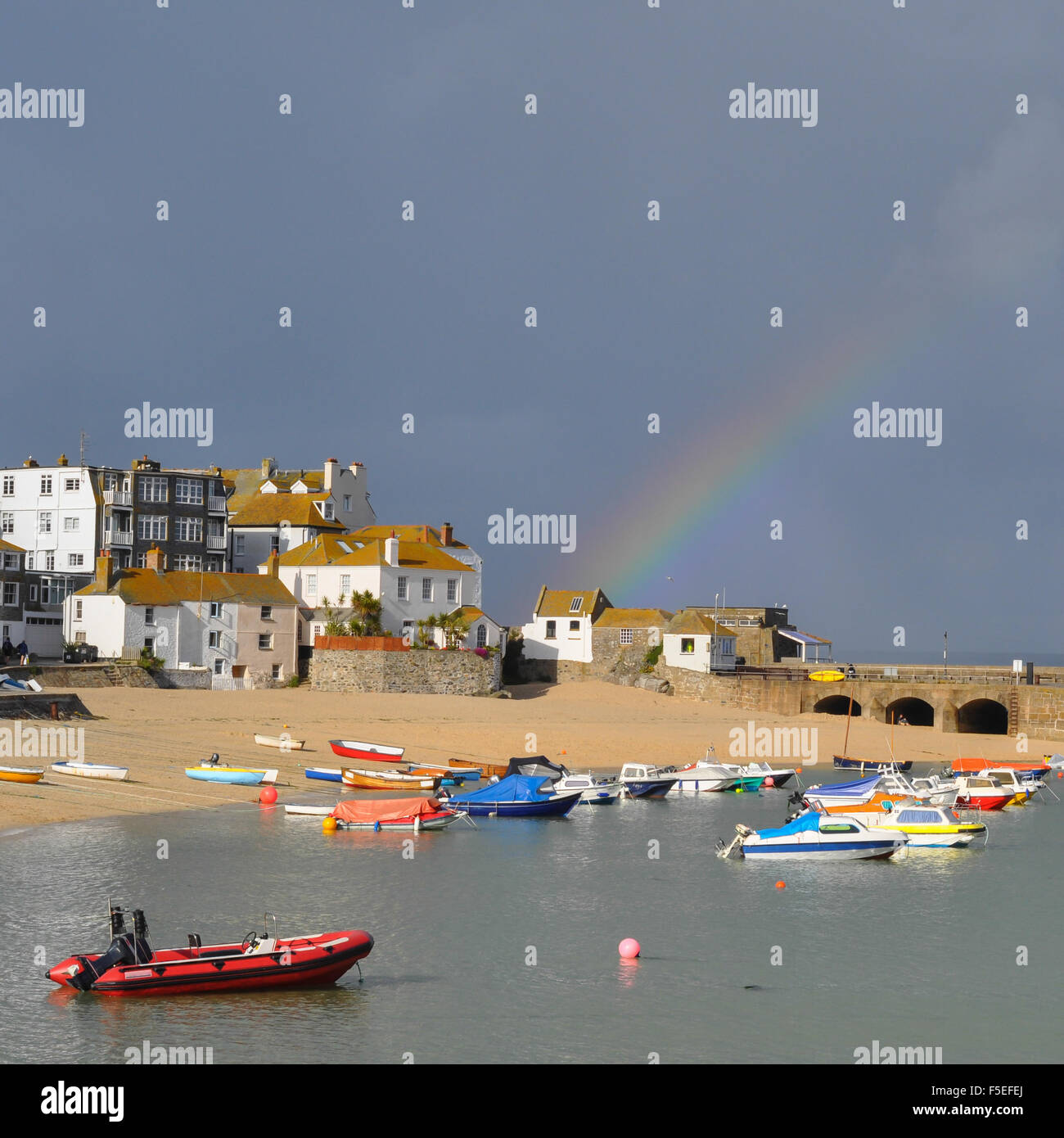 St Ives arcobaleno - un bellissimo arcobaleno su vivacemente colorate barche da pesca nella pittoresca english seaside beach e dal porto Foto Stock