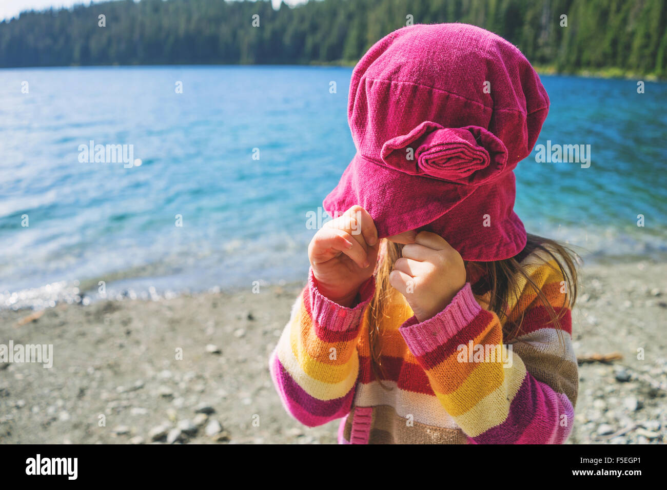 Ragazza tirando il suo cappello verso il basso sopra il suo volto Foto Stock