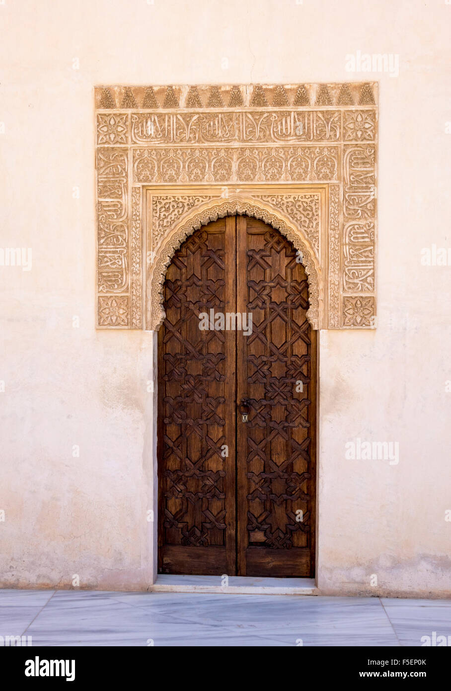 Porta di legno ornato di arco scolpito nel cortile del palazzo dell'Alhambra di Granada, Spagna Foto Stock