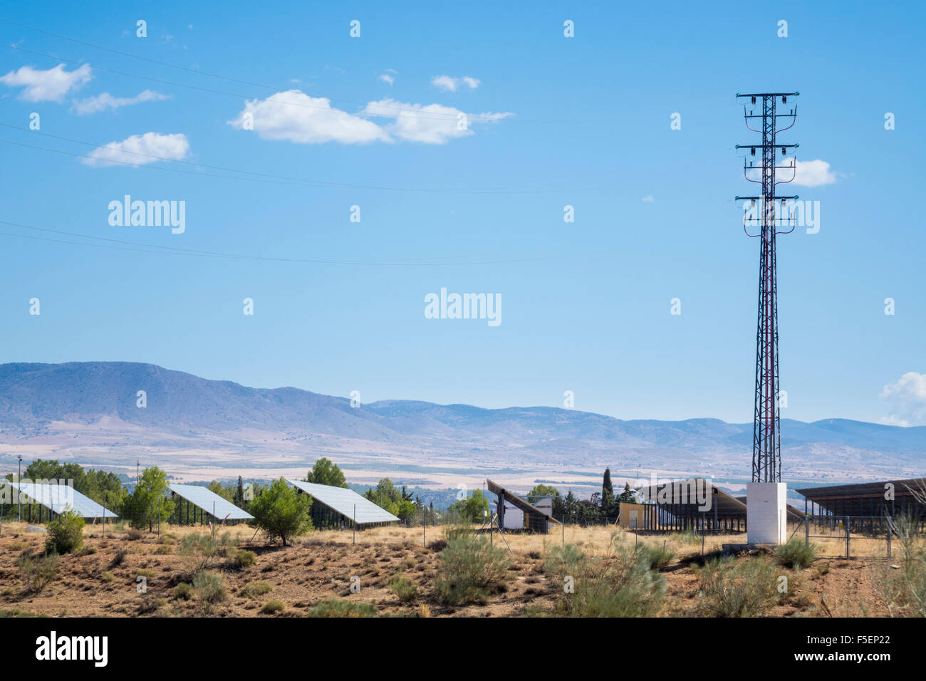 Fila di pannelli solari e traliccio di energia elettrica in corrispondenza di solar farm nel sud della Spagna Foto Stock