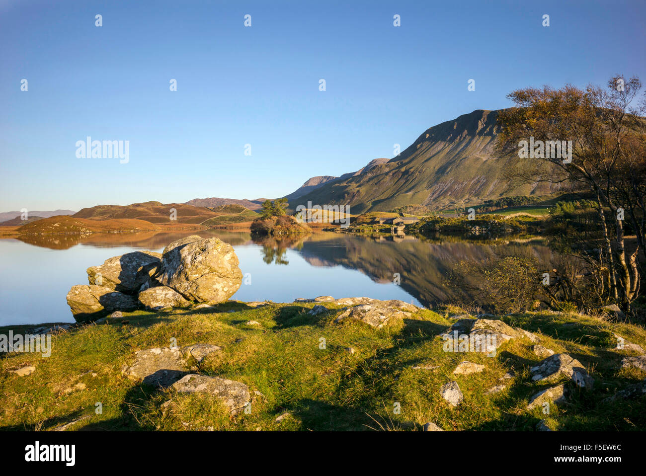 Il tardo autunno sun su Cregennan dei laghi dominati dal cader Idris mountain range specchiata nei laghi ancora Foto Stock