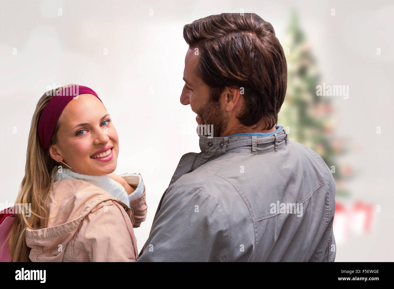 Immagine composita di uomo sorridente avente braccio attorno alla ragazza guardando la fotocamera Foto Stock