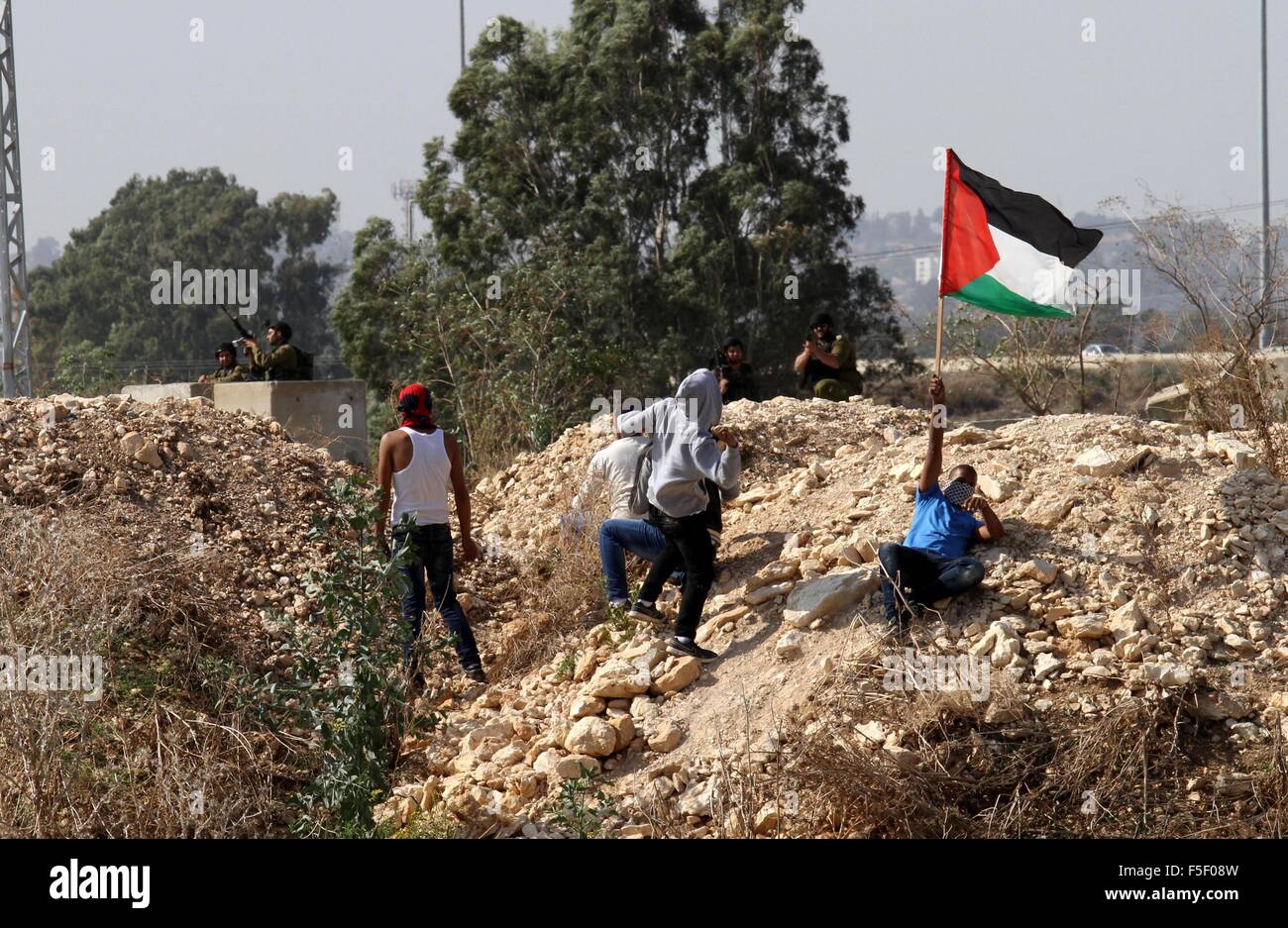 Tulkarm, West Bank, Territorio palestinese. 3 Novembre, 2015. Un manifestante palestinese getta pietre verso forze di sicurezza israeliane durante scontri nei pressi di Israeliani controversa barriera di separazione in Cisgiordania città di Tulkarm, 3 novembre 2015. Nel frattempo, le forze israeliane hanno inizio 03 Novembre hanno perquisito una stazione radio in Cisgiordania città di Hebron e ordinato che arresta il sistema per un periodo di sei mesi, i funzionari palestinesi detto credito: Nedal Eshtayah APA/images/ZUMA filo/Alamy Live News Foto Stock