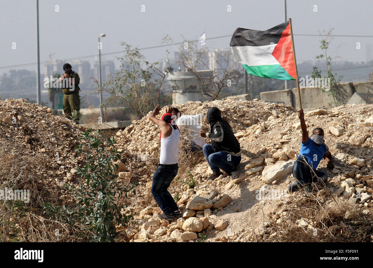 Tulkarm, West Bank, Territorio palestinese. 3 Novembre, 2015. Un manifestante palestinese getta pietre verso forze di sicurezza israeliane durante scontri nei pressi di Israeliani controversa barriera di separazione in Cisgiordania città di Tulkarm, 3 novembre 2015. Nel frattempo, le forze israeliane hanno inizio 03 Novembre hanno perquisito una stazione radio in Cisgiordania città di Hebron e ordinato che arresta il sistema per un periodo di sei mesi, i funzionari palestinesi detto credito: Nedal Eshtayah APA/images/ZUMA filo/Alamy Live News Foto Stock