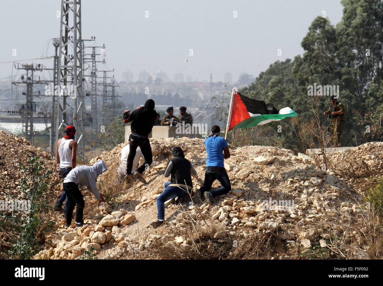 Tulkarm, West Bank, Territorio palestinese. 3 Novembre, 2015. I dimostranti palestinesi scagliare pietre verso forze di sicurezza israeliane durante scontri nei pressi di Israeliani controversa barriera di separazione in Cisgiordania città di Tulkarm, 3 novembre 2015. Nel frattempo, le forze israeliane hanno inizio 03 Novembre hanno perquisito una stazione radio in Cisgiordania città di Hebron e ordinato che arresta il sistema per un periodo di sei mesi, i funzionari palestinesi detto credito: Nedal Eshtayah APA/images/ZUMA filo/Alamy Live News Foto Stock