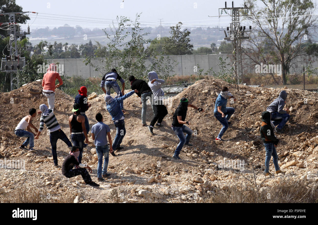 Tulkarm, West Bank, Territorio palestinese. 3 Novembre, 2015. I dimostranti palestinesi scagliare pietre verso forze di sicurezza israeliane durante scontri nei pressi di Israeliani controversa barriera di separazione in Cisgiordania città di Tulkarm, 3 novembre 2015. Nel frattempo, le forze israeliane hanno inizio 03 Novembre hanno perquisito una stazione radio in Cisgiordania città di Hebron e ordinato che arresta il sistema per un periodo di sei mesi, i funzionari palestinesi detto credito: Nedal Eshtayah APA/images/ZUMA filo/Alamy Live News Foto Stock