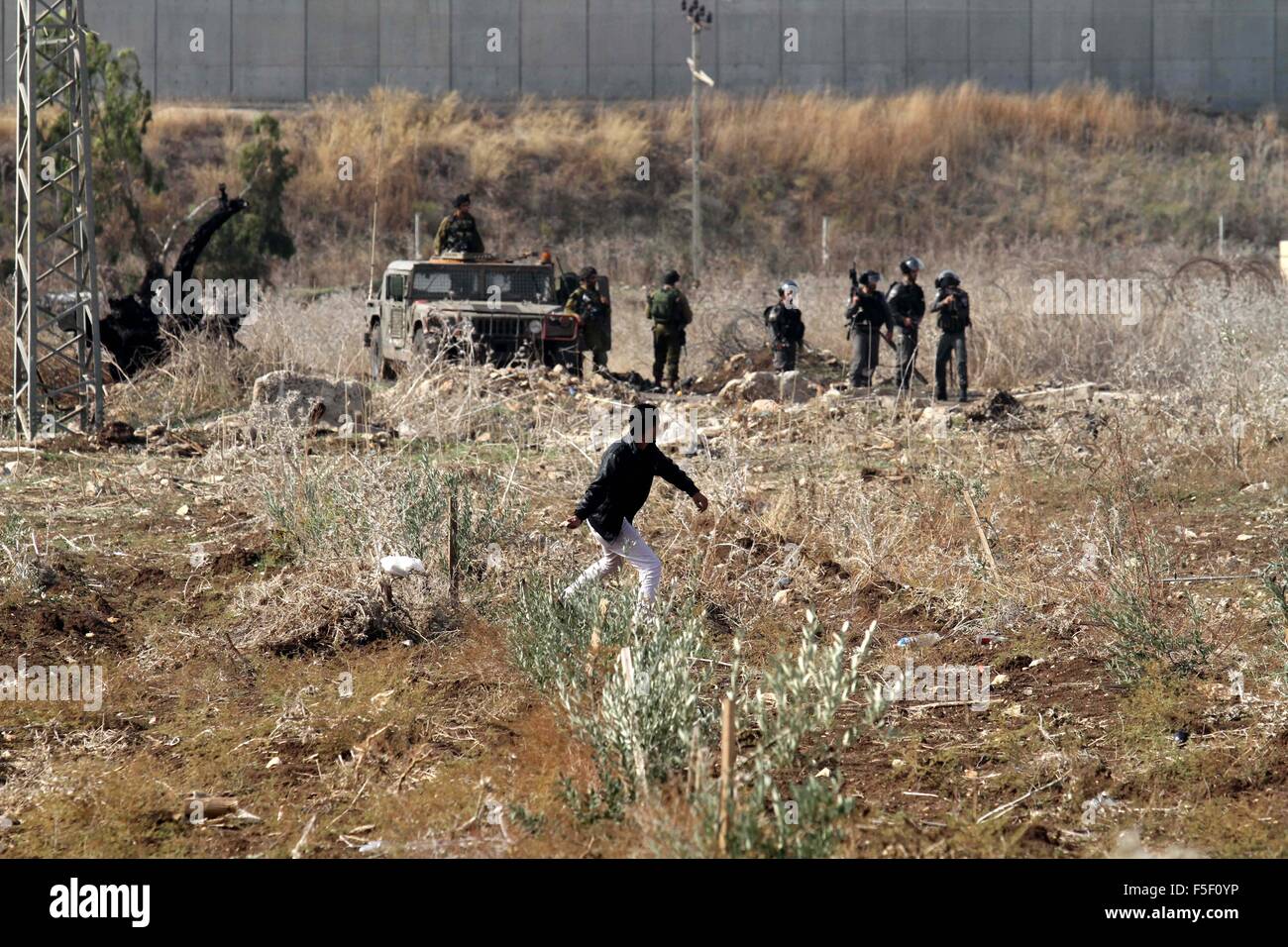 Tulkarm, West Bank, Territorio palestinese. 3 Novembre, 2015. Un manifestante palestinese getta pietre verso forze di sicurezza israeliane durante scontri nei pressi di Israeliani controversa barriera di separazione in Cisgiordania città di Tulkarm, 3 novembre 2015. Nel frattempo, le forze israeliane hanno inizio 03 Novembre hanno perquisito una stazione radio in Cisgiordania città di Hebron e ordinato che arresta il sistema per un periodo di sei mesi, i funzionari palestinesi detto credito: Nedal Eshtayah APA/images/ZUMA filo/Alamy Live News Foto Stock