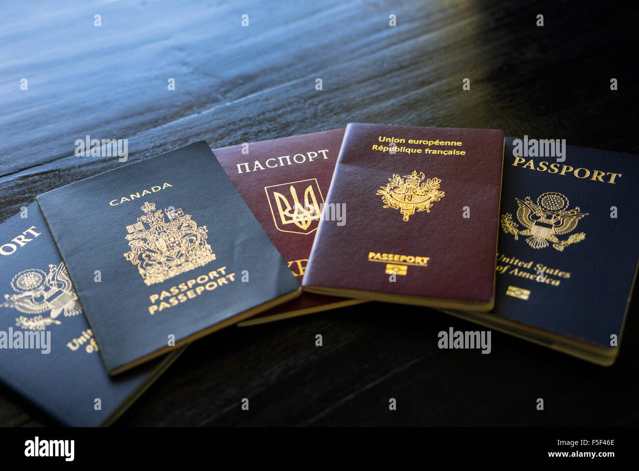 Un set di passaporti internazionali su un nero lo sfondo di legno Foto Stock