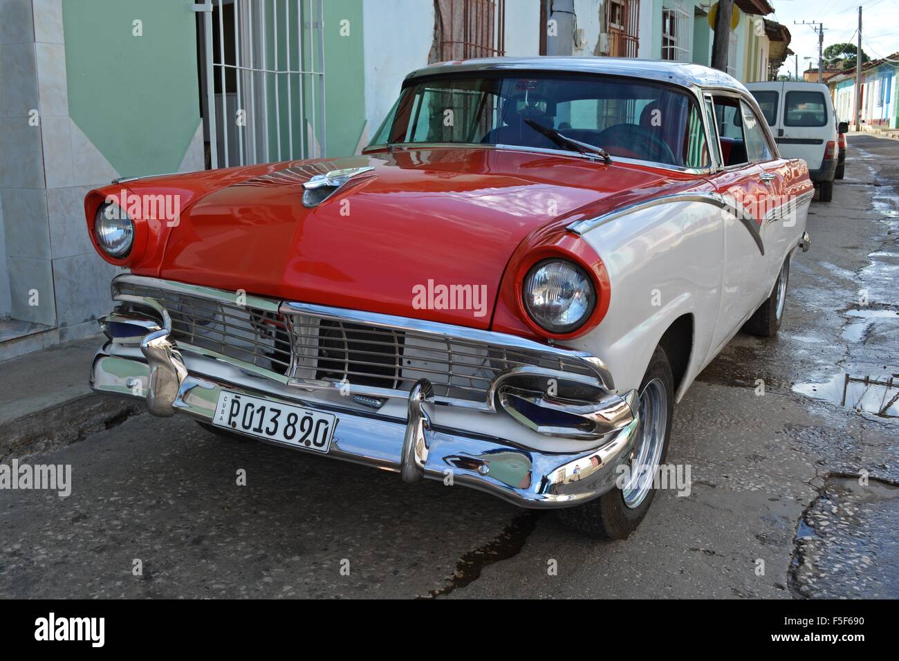 Vintage di colore rosso e bianco Ford auto parcheggiate su di una tranquilla strada ombreggiata in Trinidad, Cuba Foto Stock