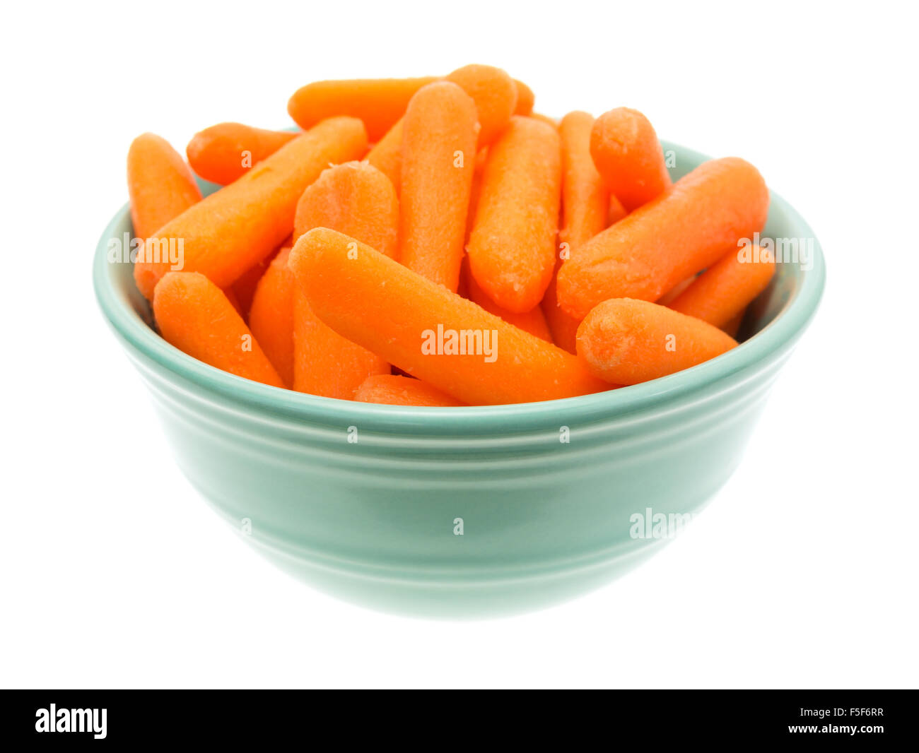 Un grande servizio di organico piccolo bimbo le carote in una ciotola verde isolato su uno sfondo bianco. Foto Stock
