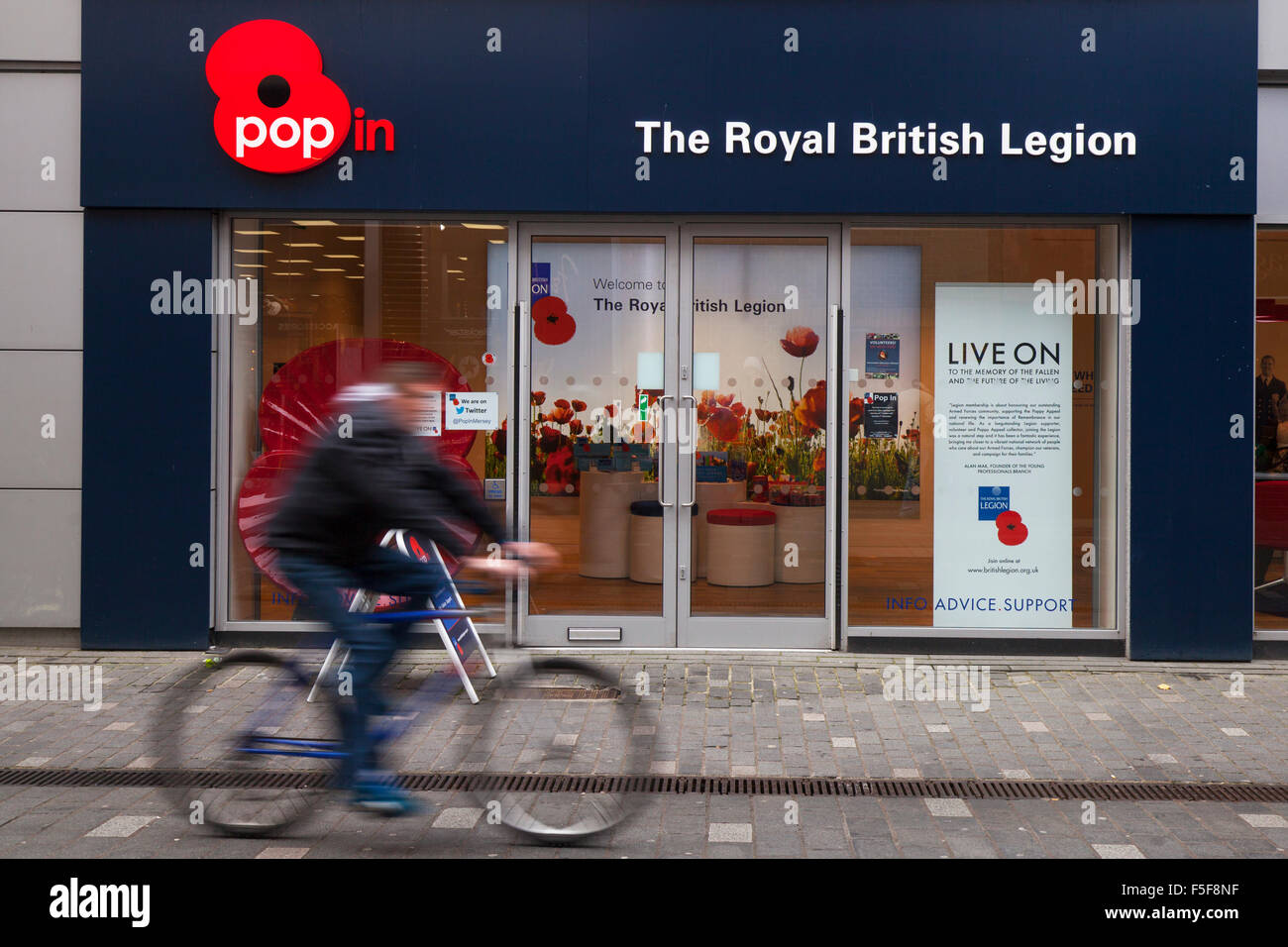 Persone che passano New Royal British Legion Pop in Shop a Williamson Street, Liverpool, Merseyside, Regno Unito Foto Stock