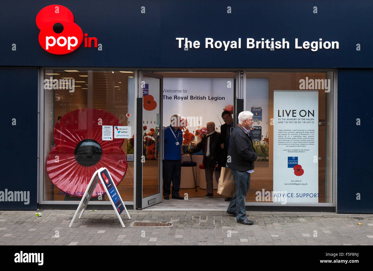 Persone che passano New Royal British Legion Pop in Shop a Williamson Street, Liverpool, Merseyside, Regno Unito Foto Stock