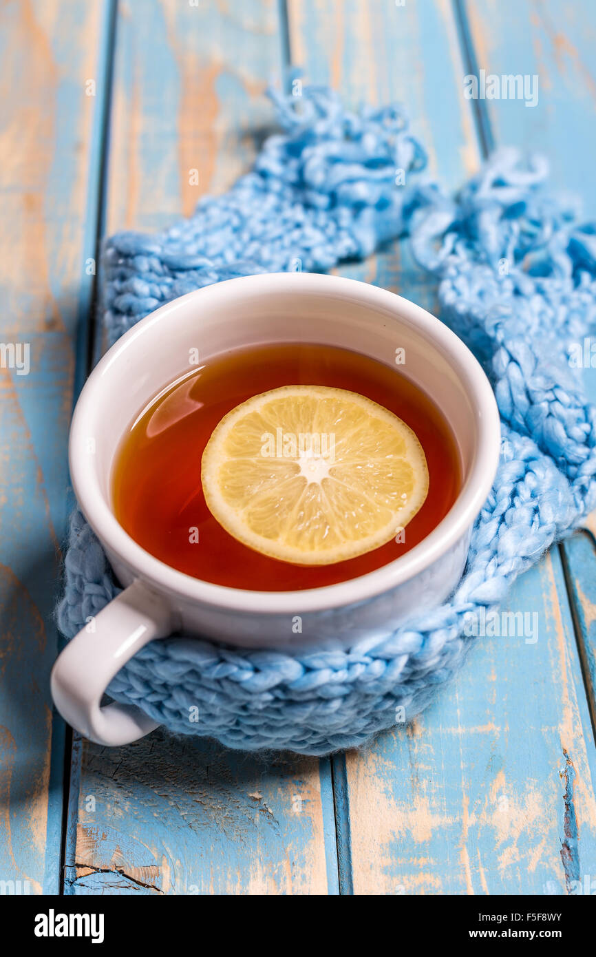 Orario invernale: tazza di tè caldo con limone e sciarpa Foto Stock