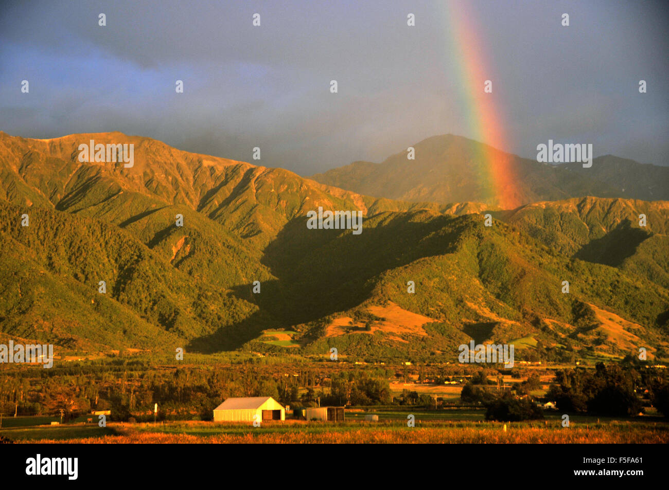 Rainbow oltre le montagne all'alba, Kaikoura, Isola del Sud, Nuova Zelanda Foto Stock