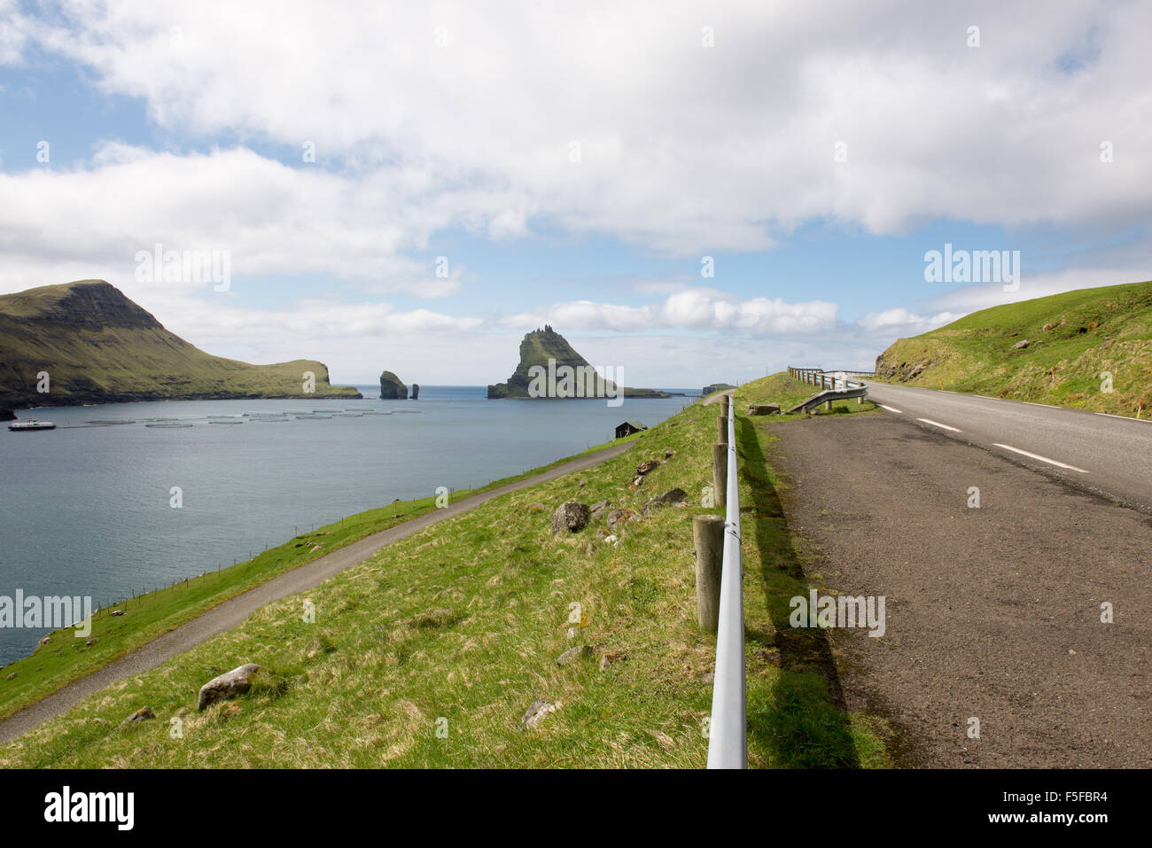 L'isola gasholmur sulle isole Faerøer con allevamento di salmoni come si vede da una strada a funzionario ministeriale Foto Stock