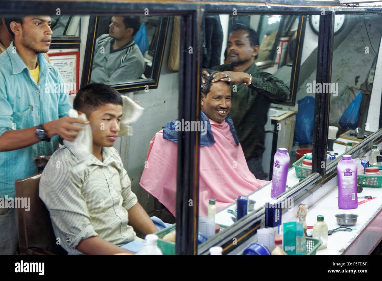Kathmandu, Nepal - 3 Novembre 2013: Non identificato la gente locale avente un taglio di capelli al barbiere per le strade di Kathmandu Foto Stock