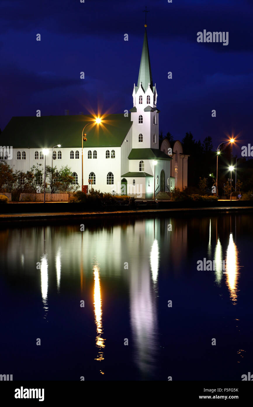 Frikirkjan Chiesa riflessa sul laghetto Tjorning, Reykjavik, Islanda Foto Stock