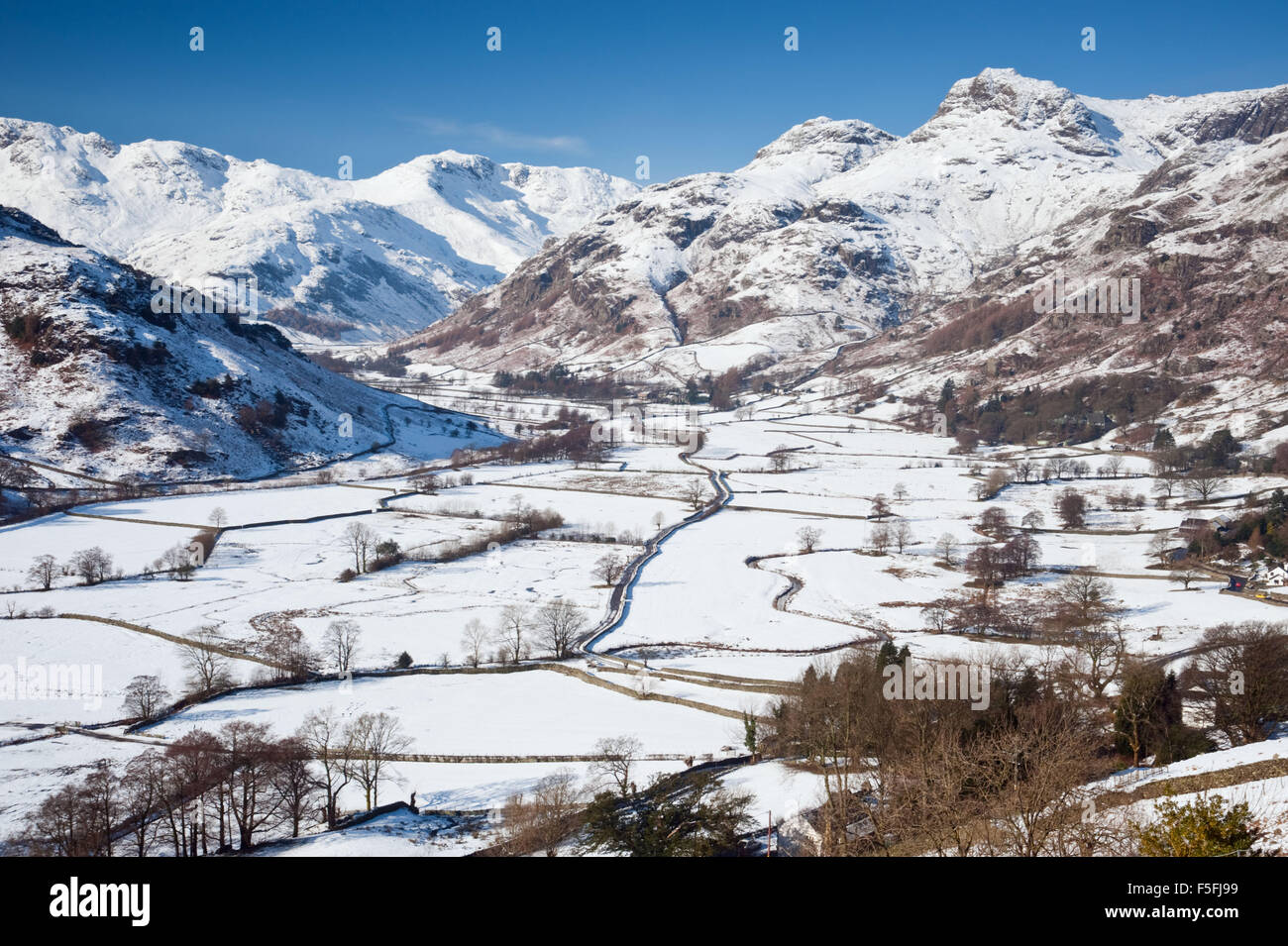 Vista di Langdale e The Langdale Pikes nel Parco Nazionale del Distretto dei Laghi, UK, su una gloriosa giornata di sole dopo una notte di neve. Foto Stock