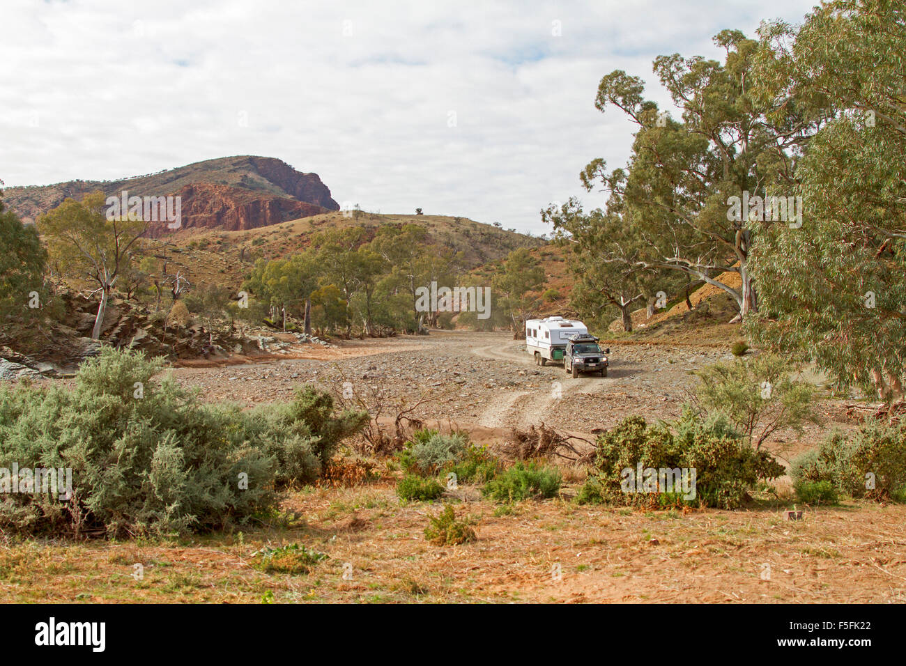 Caravan trainato da 4x4 veicolo che viaggia lungo la via su terreni sassosi riverbed attraverso colline a Mount Chambers Gorge, outback Australia del Sud Foto Stock