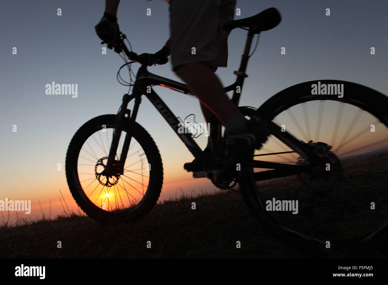 Laguna Beach, California, Stati Uniti d'America. 06 Maggio, 2012. Il pilota di MTB TIM LANE in silhouette al tramonto passeggiate lungo i sentieri in Aliso e legno Canyon Wilderness Park vicino alla laguna costiera deserto. Il parco è parte dell'OC (Orange County) Rete dei parchi. Mountain bike include: cross country escursioni in bicicletta, Equitazione in discesa, freeride. Lo sport richiede endurance, bike abilità di manipolazione e di autosufficienza. Si tratta di un singolo sport che possono essere eseguite quasi ovunque. Vi sono aspetti della mountain bike che sono più simili a trail running rispetto ad una normale bicicletta. Perché i piloti sono spesso lontano dalla civiltà, th Foto Stock