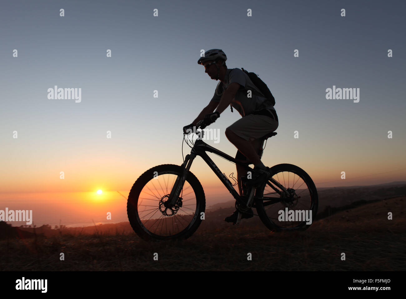Laguna Beach, California, Stati Uniti d'America. 06 Maggio, 2012. Il pilota di MTB TIM LANE in silhouette al tramonto passeggiate lungo i sentieri in Aliso e legno Canyon Wilderness Park vicino alla laguna costiera deserto. Il parco è parte dell'OC (Orange County) Rete dei parchi. Mountain bike include: cross country escursioni in bicicletta, Equitazione in discesa, freeride. Lo sport richiede endurance, bike abilità di manipolazione e di autosufficienza. Si tratta di un singolo sport che possono essere eseguite quasi ovunque. Vi sono aspetti della mountain bike che sono più simili a trail running rispetto ad una normale bicicletta. Perché i piloti sono spesso lontano dalla civiltà, th Foto Stock