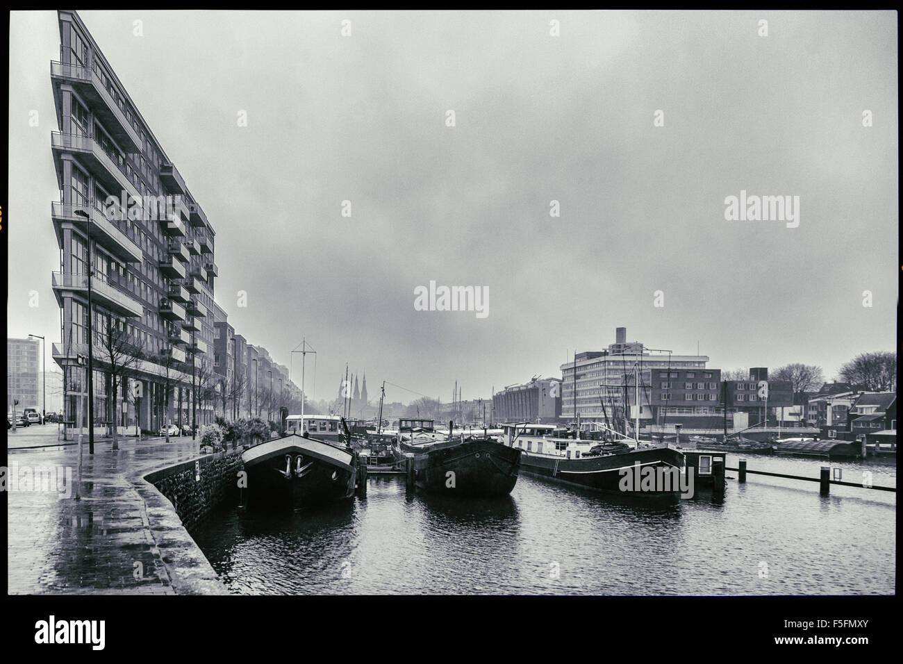 Westerdok Harbour, Amsterdam Paesi Bassi sotto il grigio cielo invernale, che vivono in case galleggianti su un canale con un unico stile di vita Foto Stock