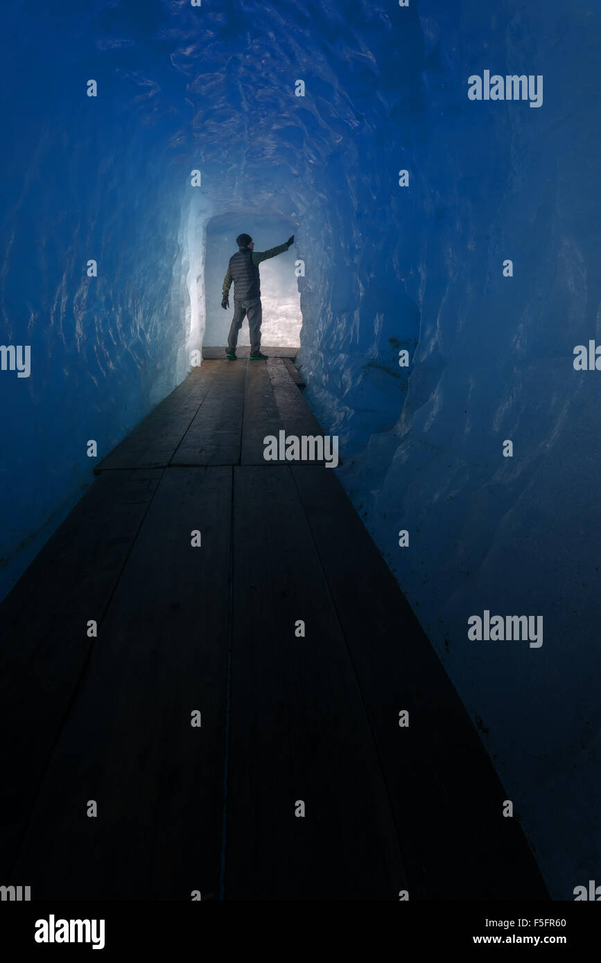 Silhouette uomo nella caverna di ghiaccio. Ghiacciaio del Rodano, Svizzera, Europa. Foto Stock