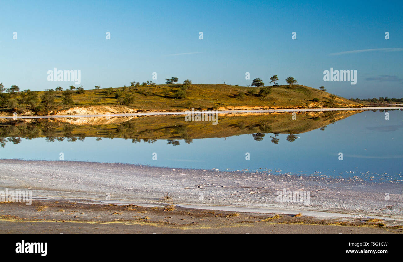 Vista panoramica della Australian Outback lago & sale incrostato banca con bassa collina & blue sky riflessa in superficie a specchio di acqua a Murray Tramonto Nat. Pk Foto Stock