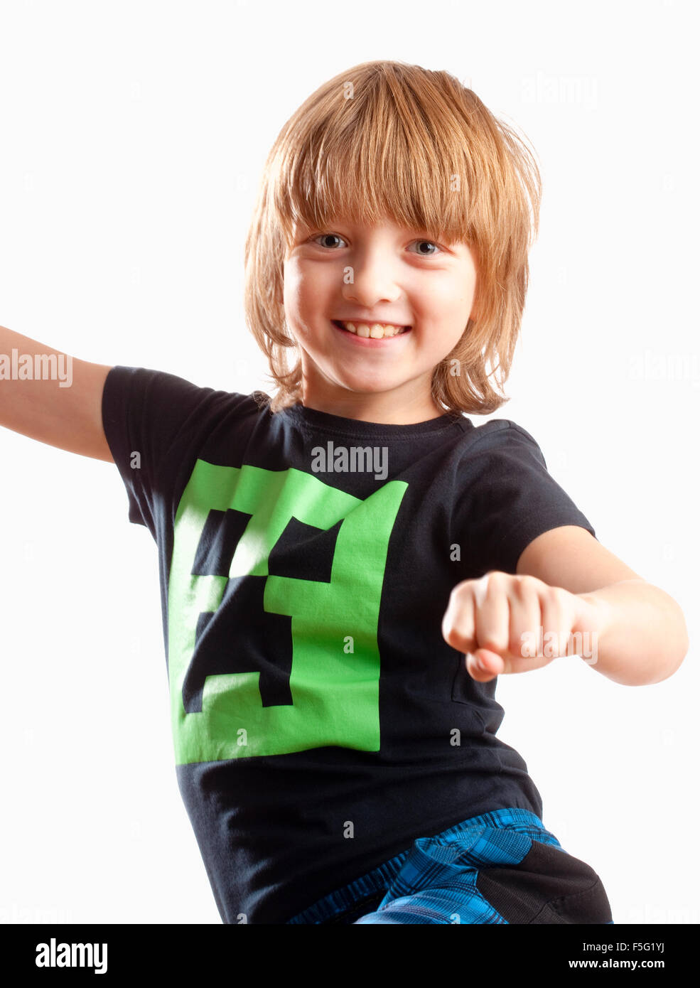 Ragazzo con capelli biondi sorridente, ballare con la musica Foto Stock
