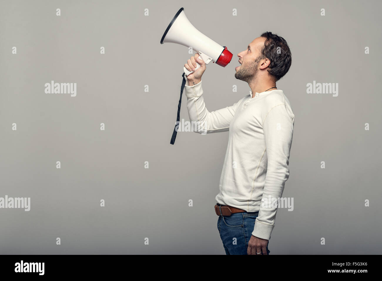 Uomo che parla in un megafono come egli fa un discorso pubblico, partecipa a una protesta o organizza un rally o promozione, oltre gr Foto Stock