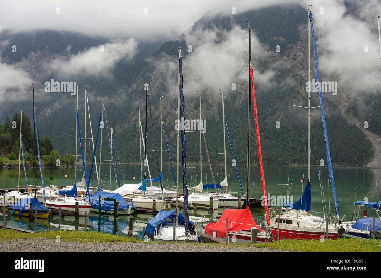 Piccolo nessun nome yacht sul foggy mountain lake sono chiusi da coperchi da una pioggia Foto Stock