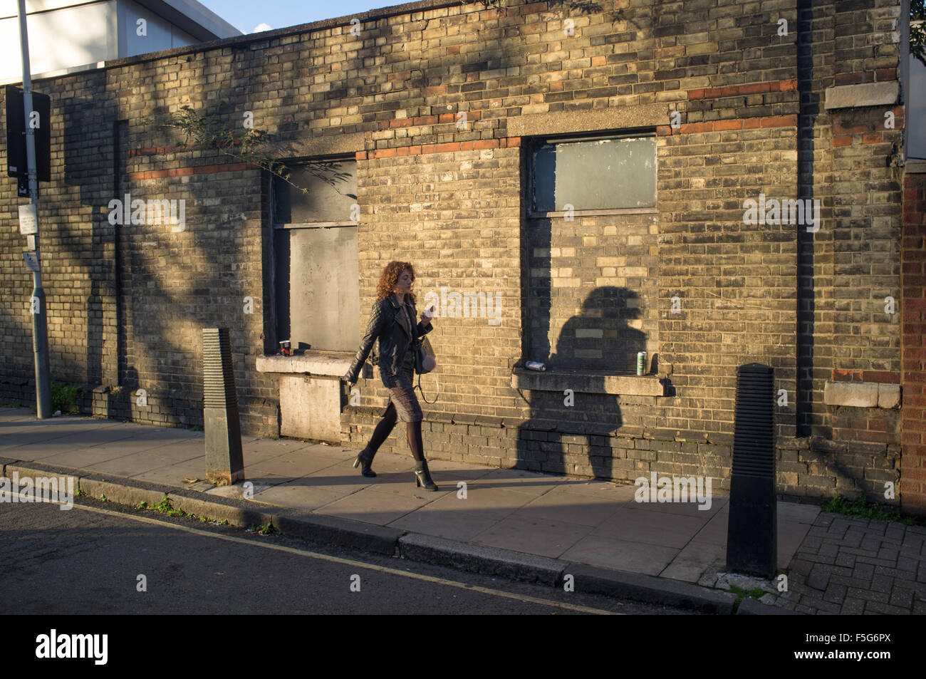 Una donna di casa a piedi su una sera d'autunno a Islington, Londra Nord Foto Stock