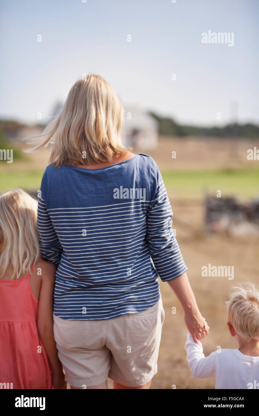 La Svezia, Gotland, Faro, Madre con figlio (2-3) e la figlia (10-11) tenendo le mani Foto Stock