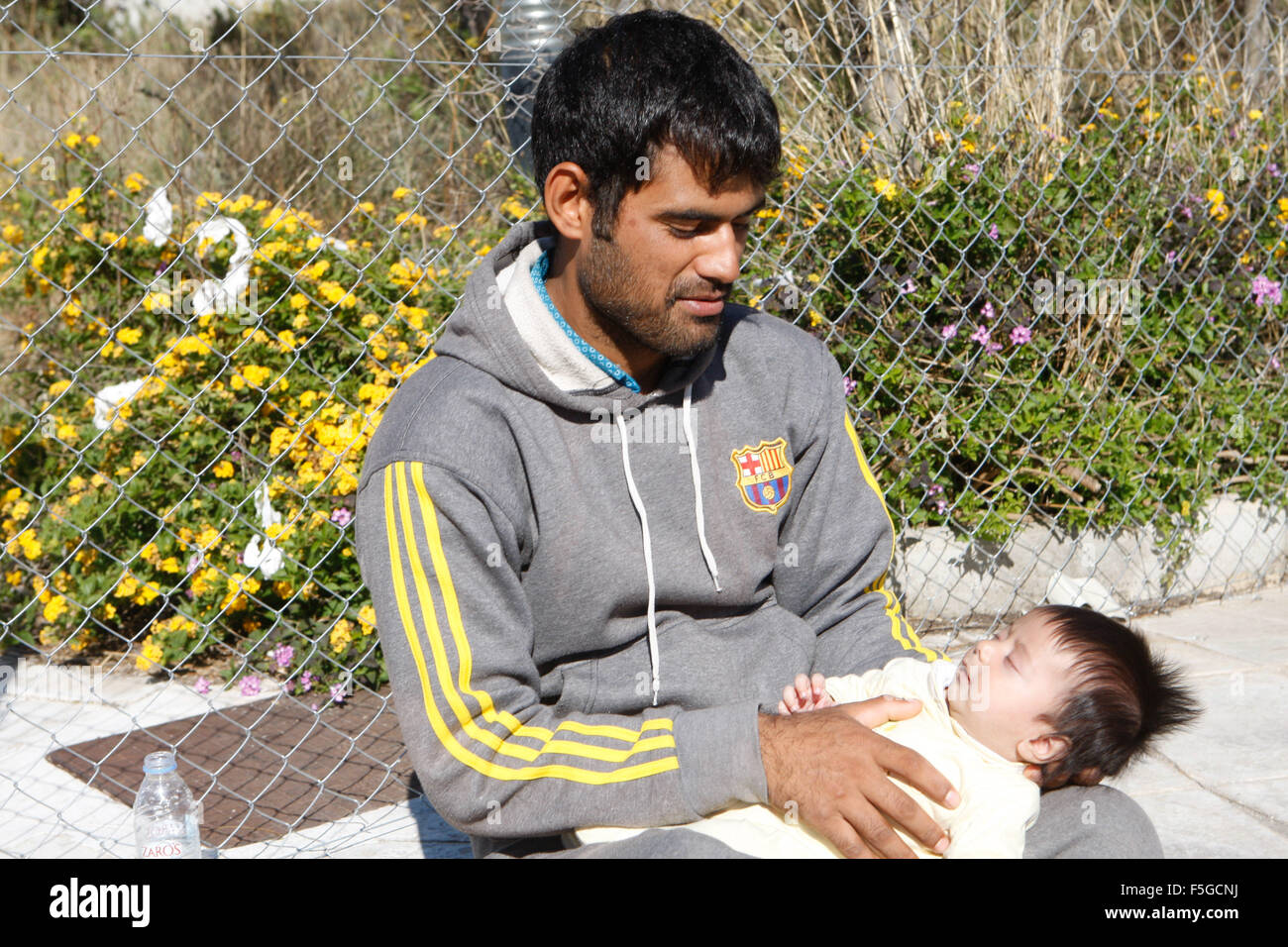 Atene, Grecia. 4 Novembre, 2015. Un padre afgano tiene il suo bambino al Galatsi Olympic Hall di Atene. La struttura in disuso, che utilizzata durante le Olimpiadi di Atene 2004, riaperto un mese fa per i migranti come più di seicentomila persone sono arrivati in Grecia finora questo anno cercando di testa per la più prospera Unione europea paesi del nord. © Aristidis Vafeiadakis/ZUMA filo/Alamy Live News Foto Stock