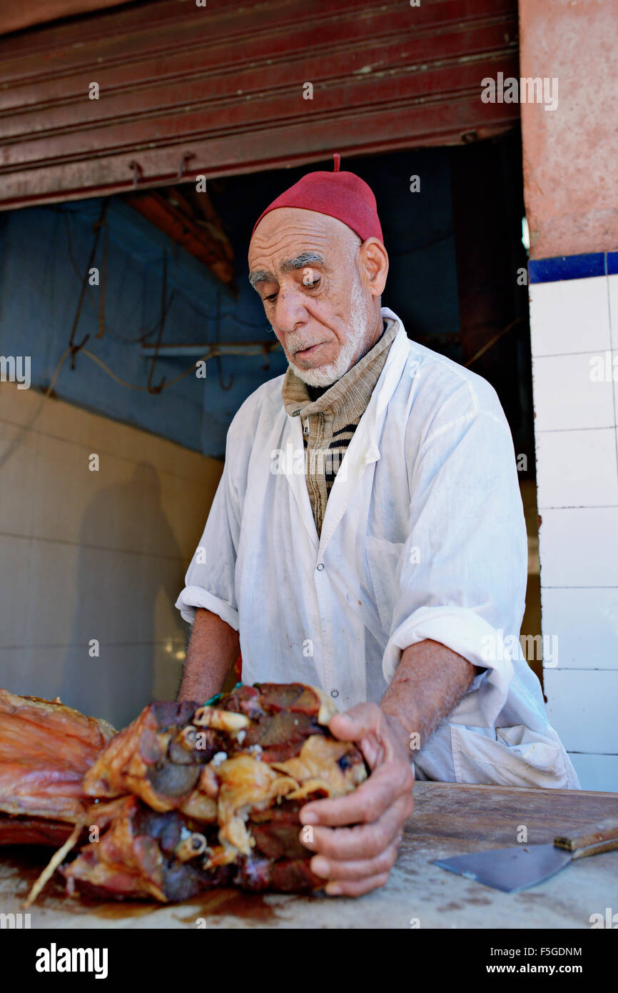 Hajd Mustapha, 69, taglio meshoui, arrosto di pecora in un forno di terra. Marrakech (Marrakech), il Marocco. Foto Stock