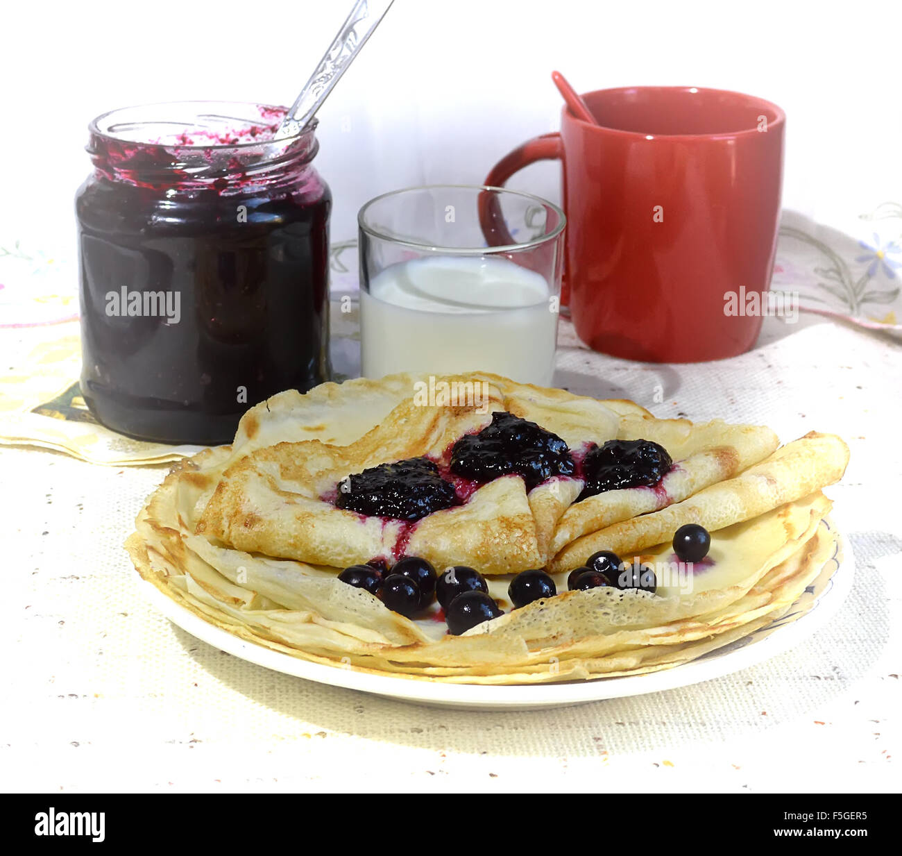 Ancora in vita con pancake, marmellate, latte e bicchiere di rosso Foto Stock