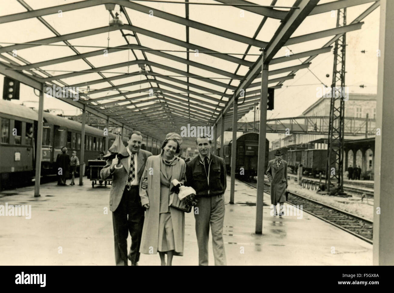 Due uomini e una donna alla stazione ferroviaria , Italia Foto Stock