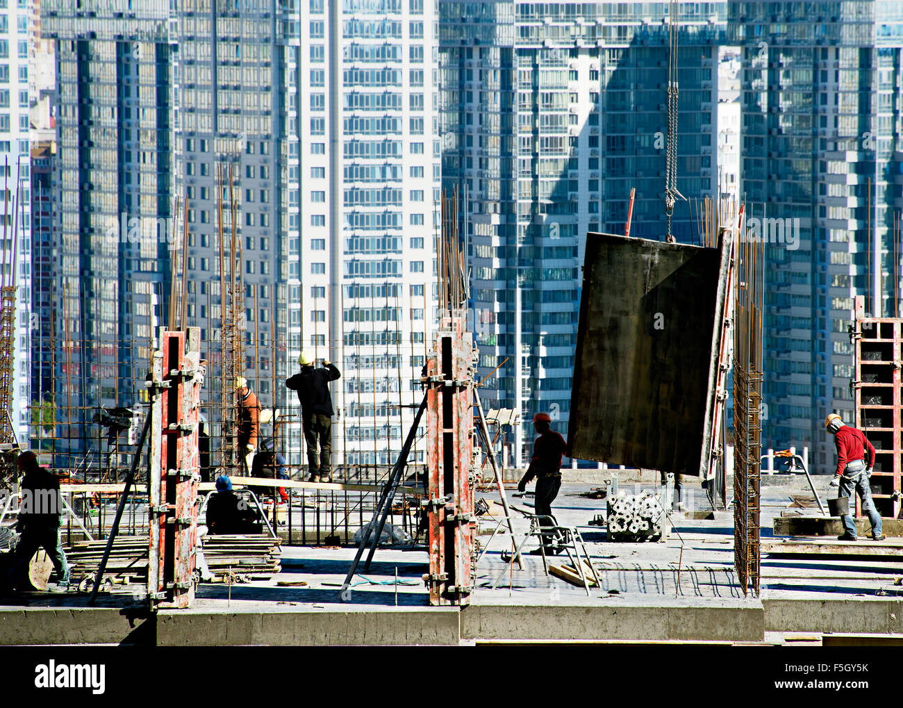 Lavoratore a un moderno grattacielo sito in costruzione Foto Stock