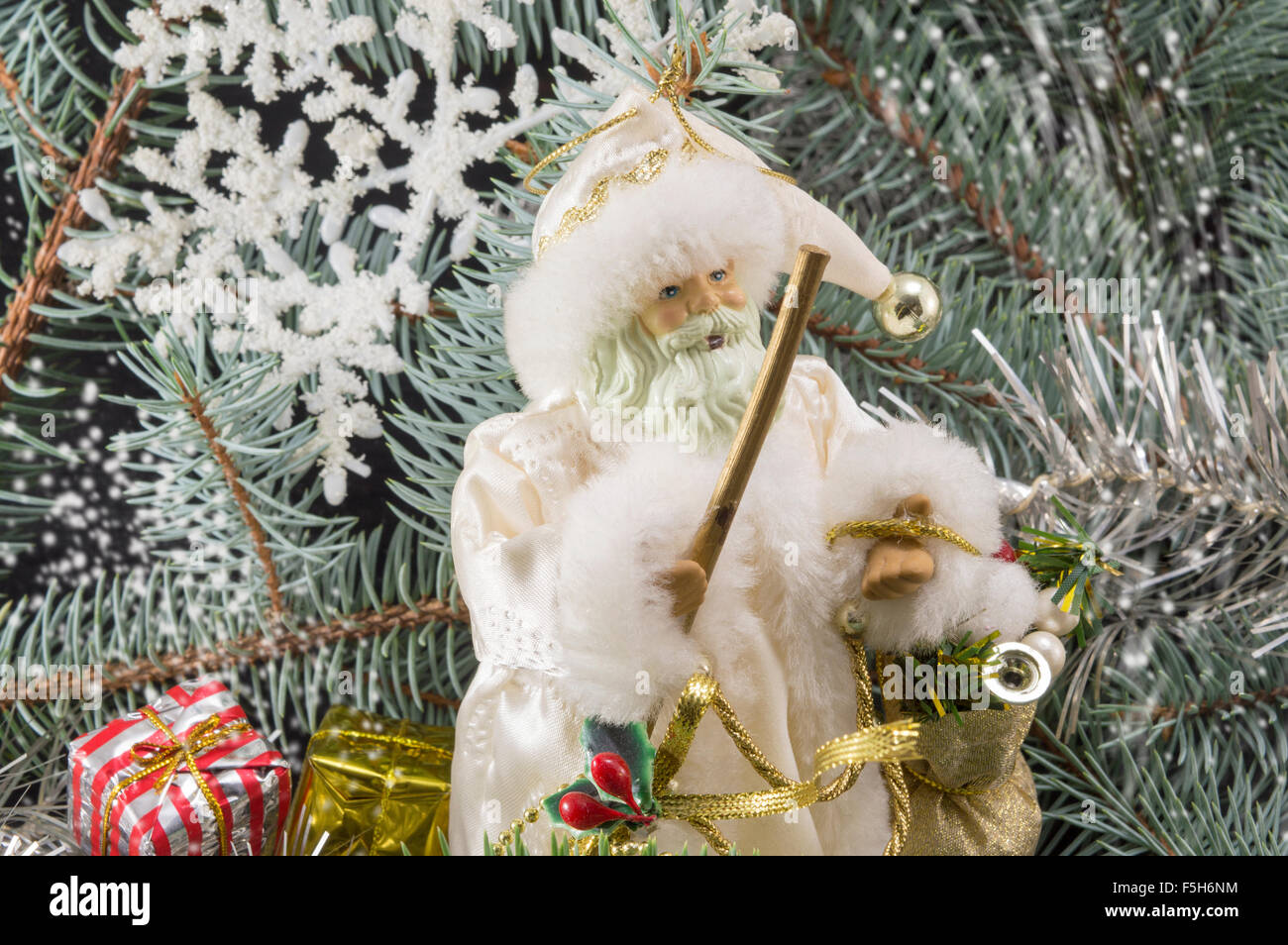 Toy Santa tra gli abeti, presenta e i fiocchi di neve. Abstract di natale Foto Stock