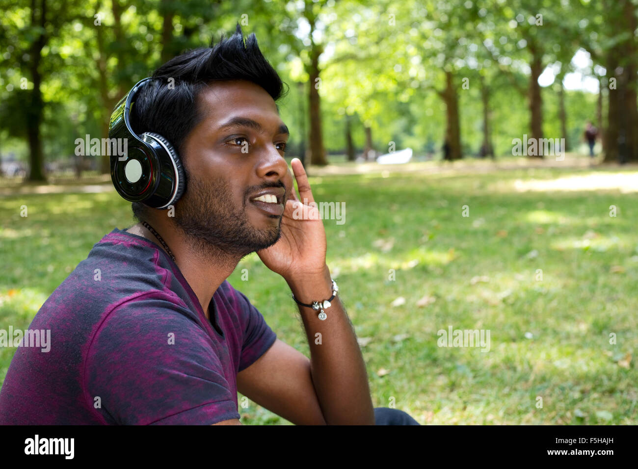 Giovane uomo ascoltare musica nel parco Foto Stock