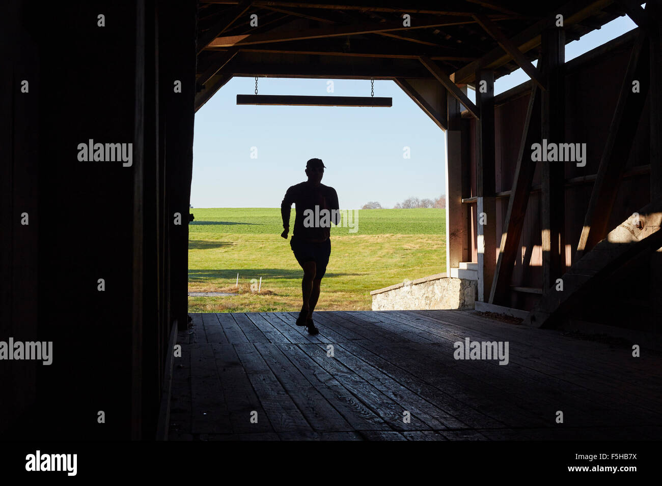 Uomo che corre attraverso un ponte coperto, Lititz, Lancaster County, Pennsylvania, STATI UNITI D'AMERICA Foto Stock
